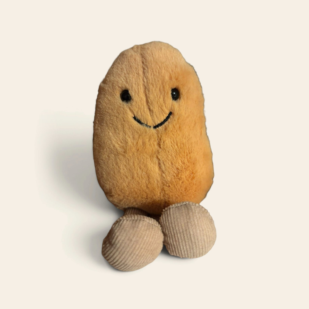 Amuseables Bean A6B: a golden brown plush bean toy with a smiling face and beige corduroy legs