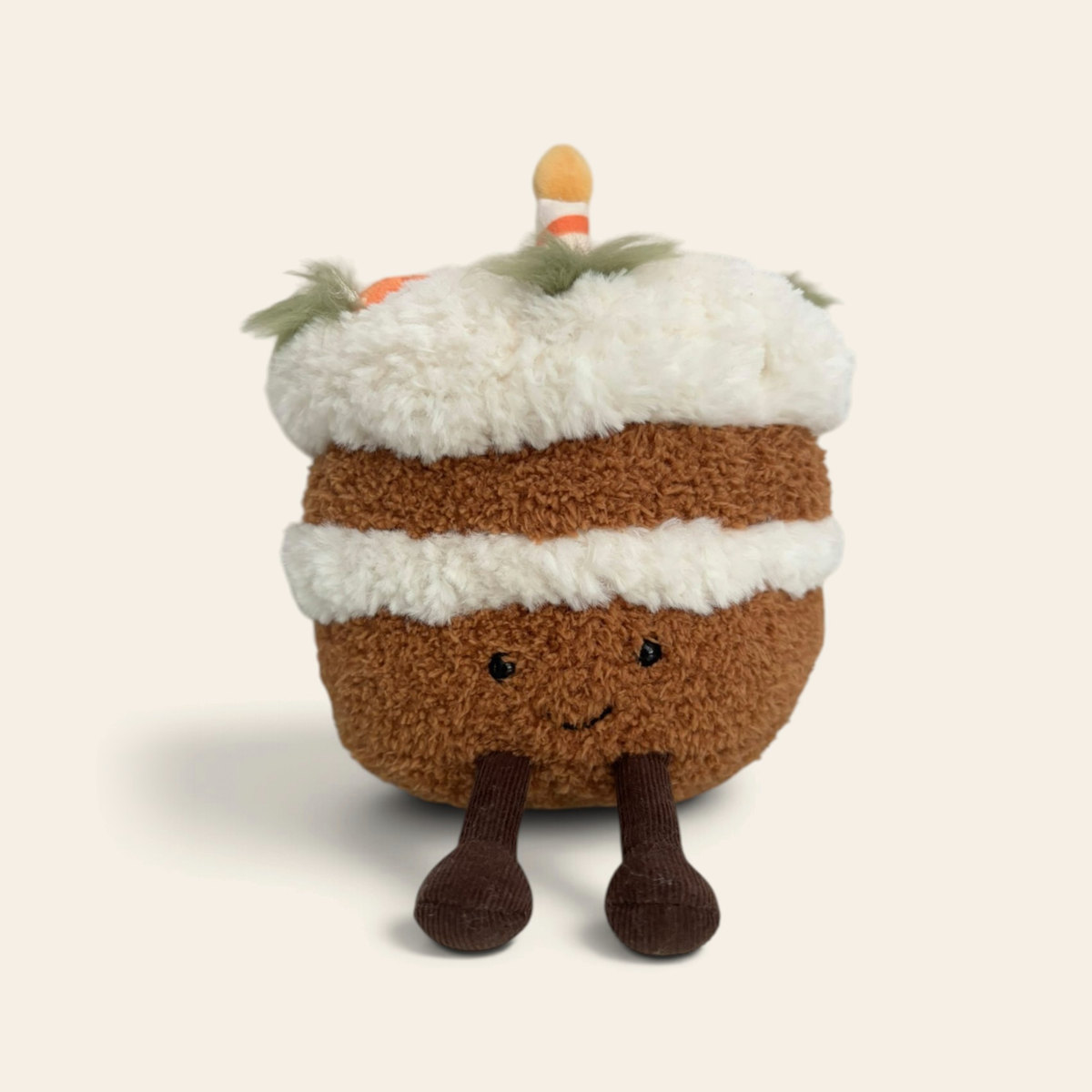 Amuseables Carrot Cake A2CRTC: a plush carrot cake slice toy with brown sponge, cream icing layers, small orange carrots on top, a smiling face and dark brown corduroy legs