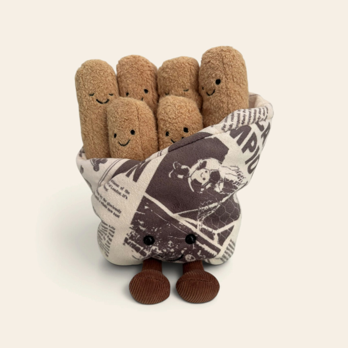 Amuseables Cosy Chips A2CCH: a bundle of smiling plush chips in a soft newspaper-print wrap, with brown corduroy legs