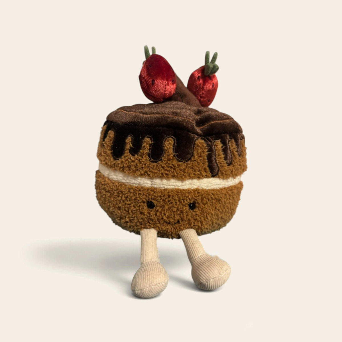 Amuseables Glacy Chocolate Cake A2CRC: a plush sponge cake with a glossy chocolate drip, a cream filling and two red strawberries on top, with cream legs