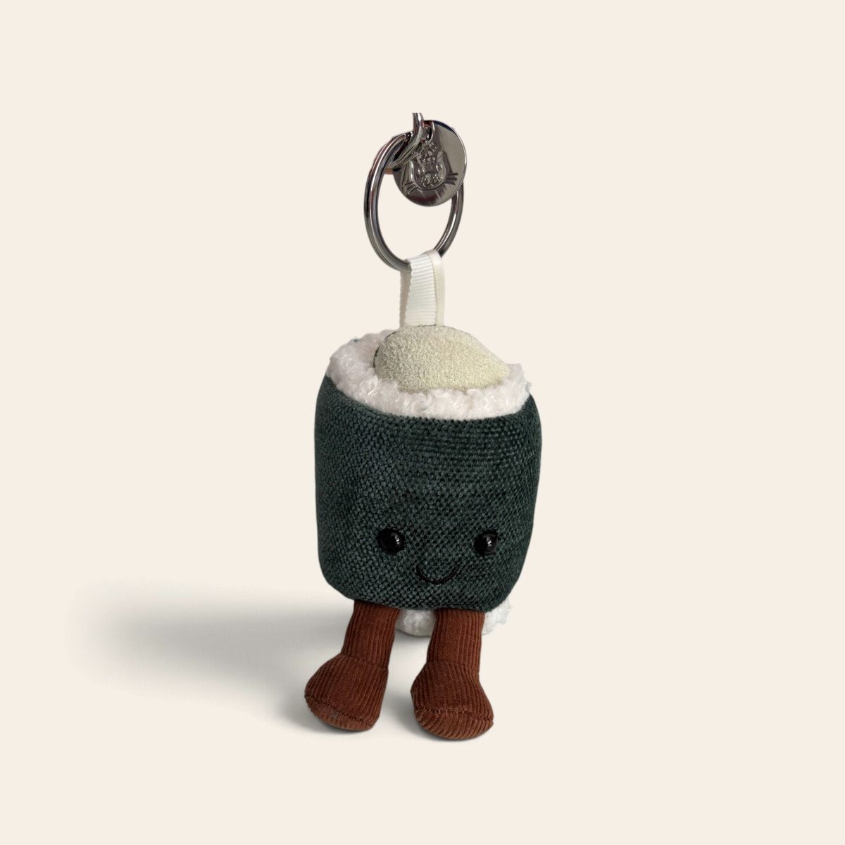 Amuseables Hosomaki Bag Charm A4CUCHBC: a small plush sushi roll with a dark green seaweed wrap, fluffy white rice, a pale green filling on top, a smiling face, brown corduroy legs and a silver key ring