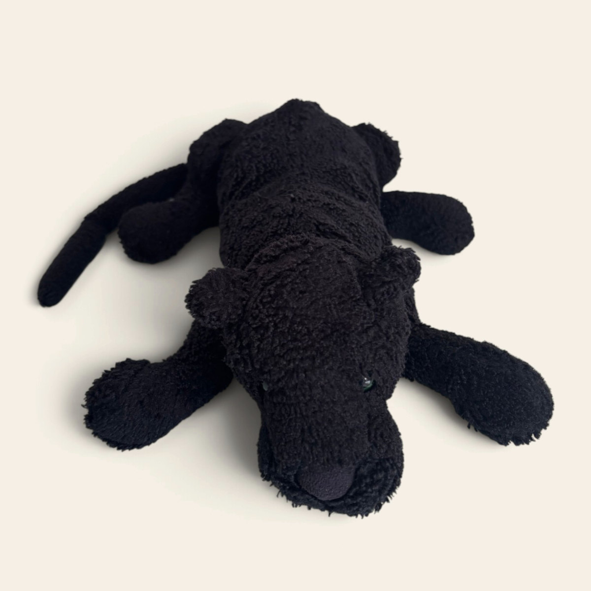 Paris Panther PP4P: a black fluffy plush panther with a long tail, lying stretched out on its tummy