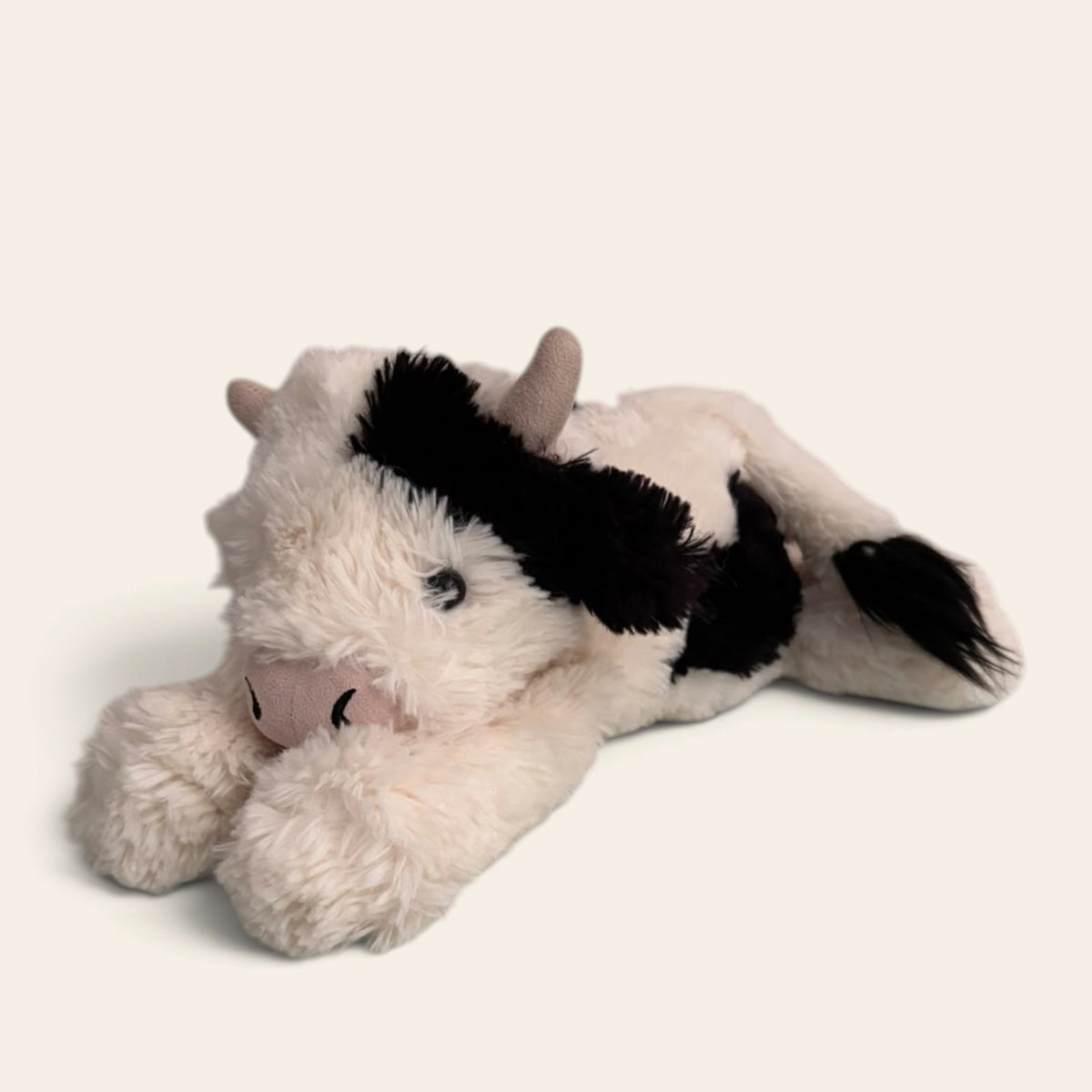 Smudge Cow SMG2C: a soft cream plush cow lying down, with black patches, small horns, a pink muzzle and a black tail tuft