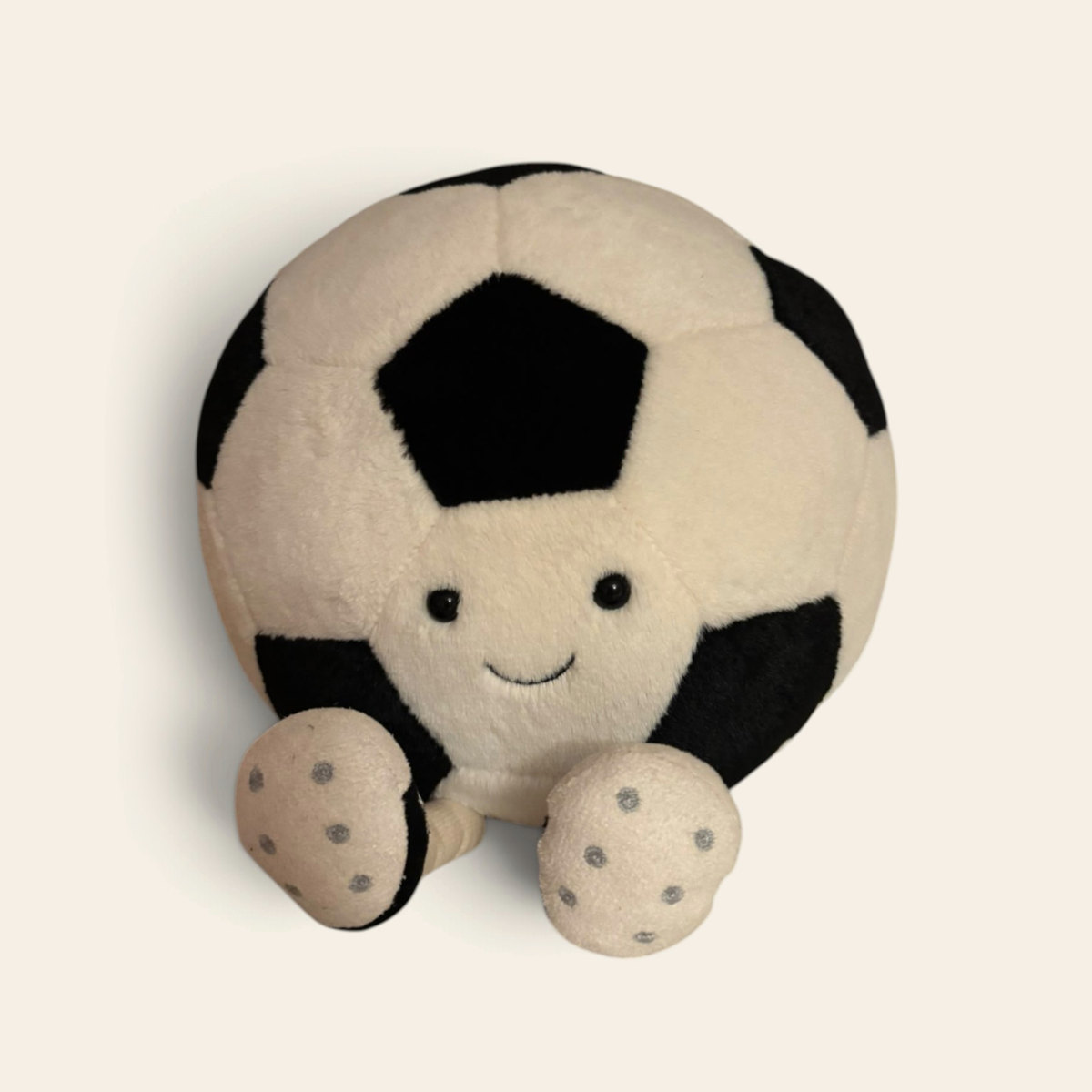 Amuseables Sports Football AS2UKF: a round cream and black plush football toy with a smiling face and stitched brown and cream feet