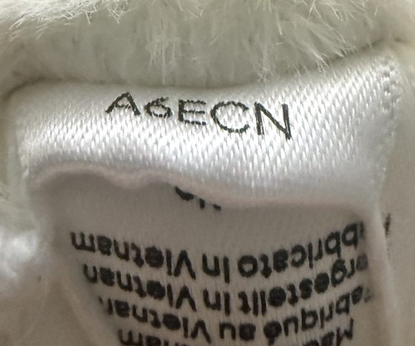 Close-up of a white sewn-in fabric tag with the product code A6ECN stitched across the top